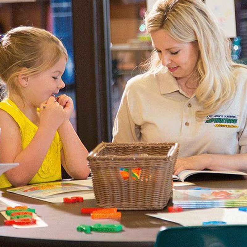 Teacher helping pre-k student with letters