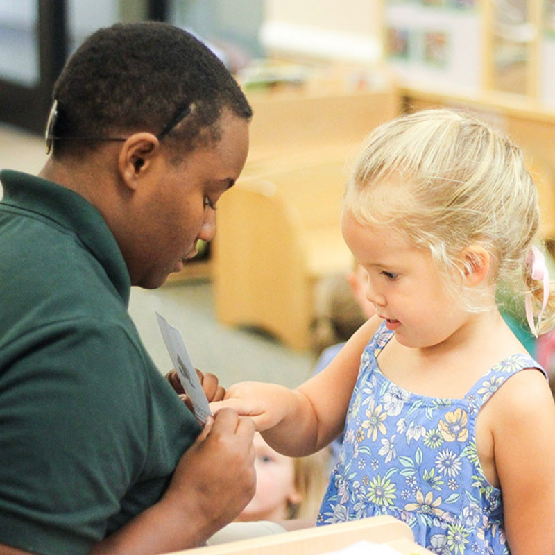 Teacher helping young girl