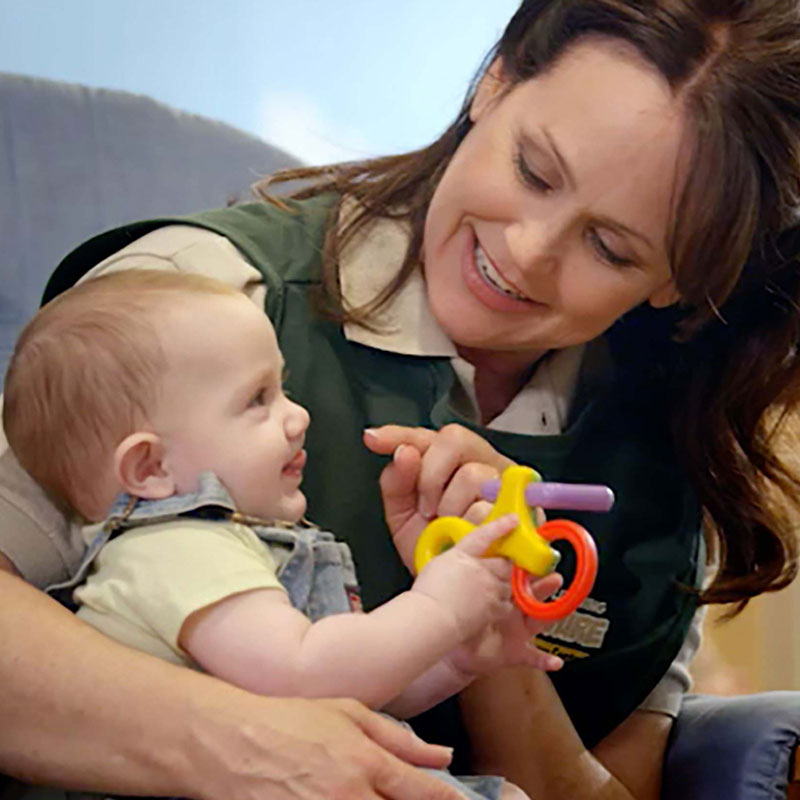 Teacher holding happy infant