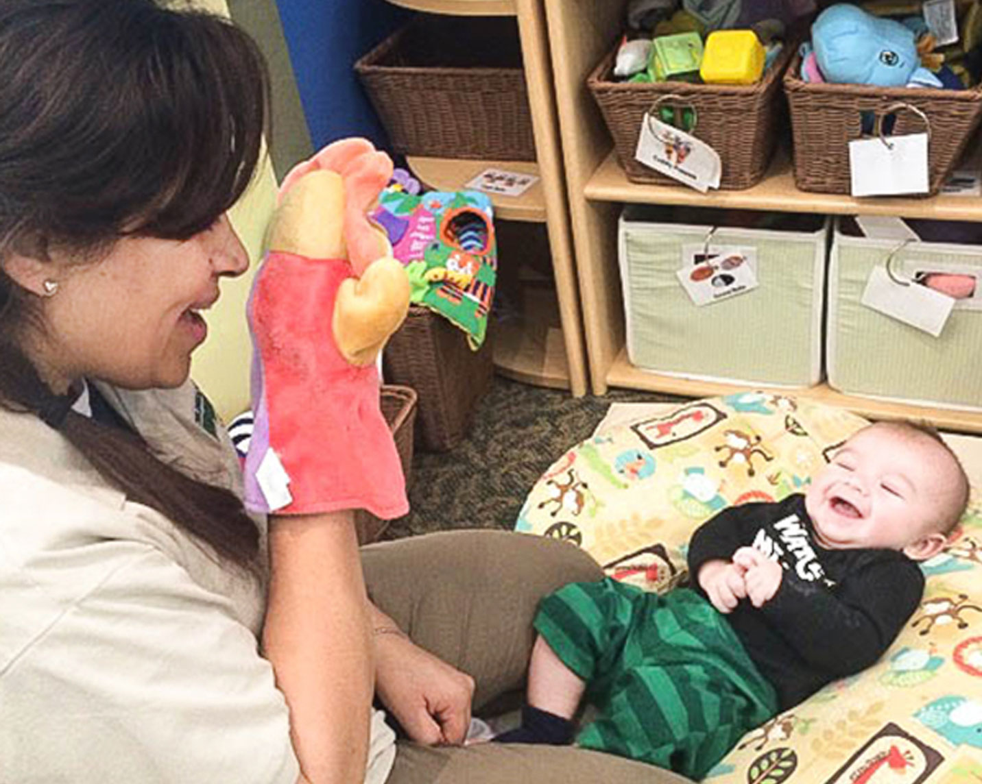 Teacher showing puppets to infant