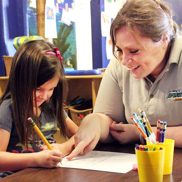 Woman helping student to write